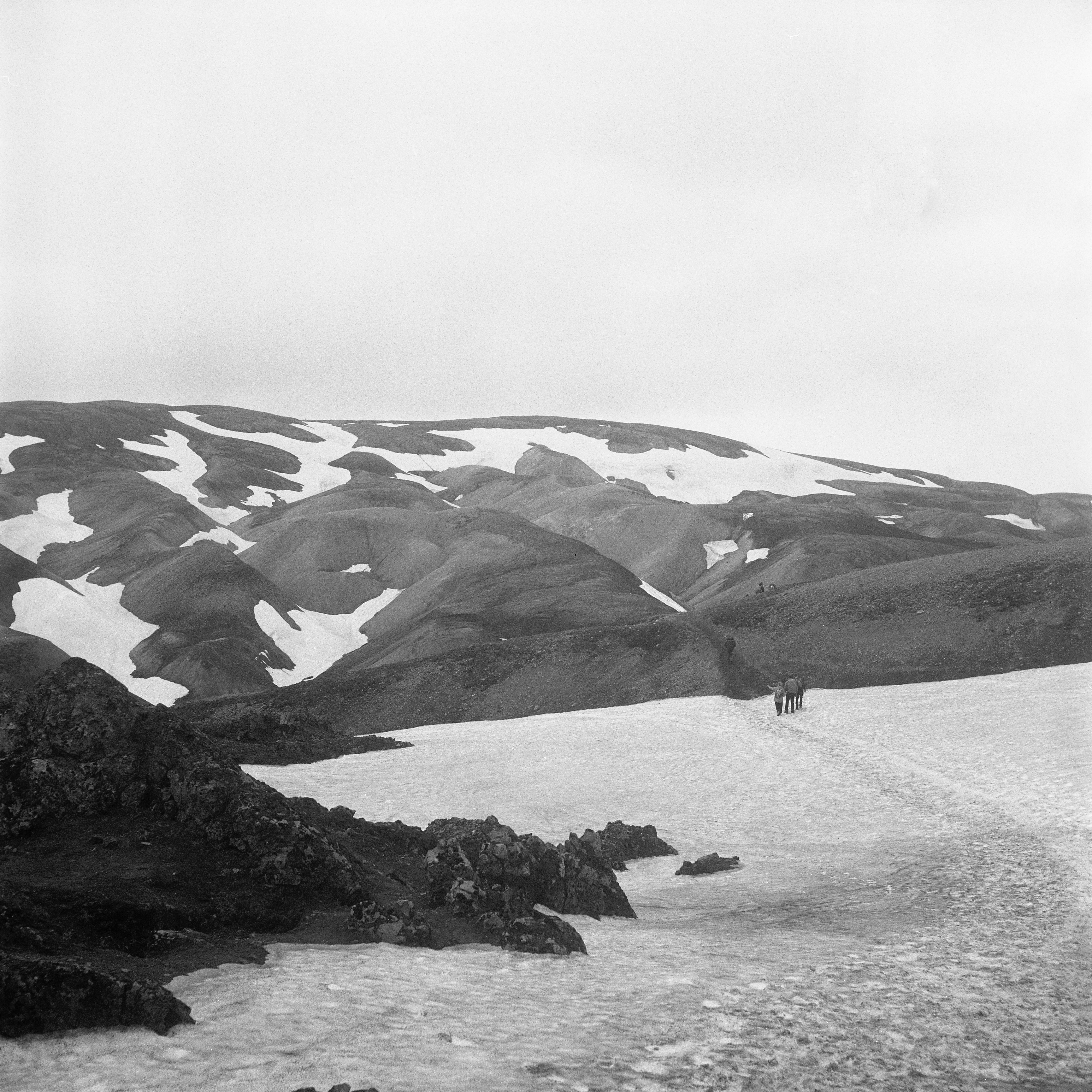 People hiking with mountains in background