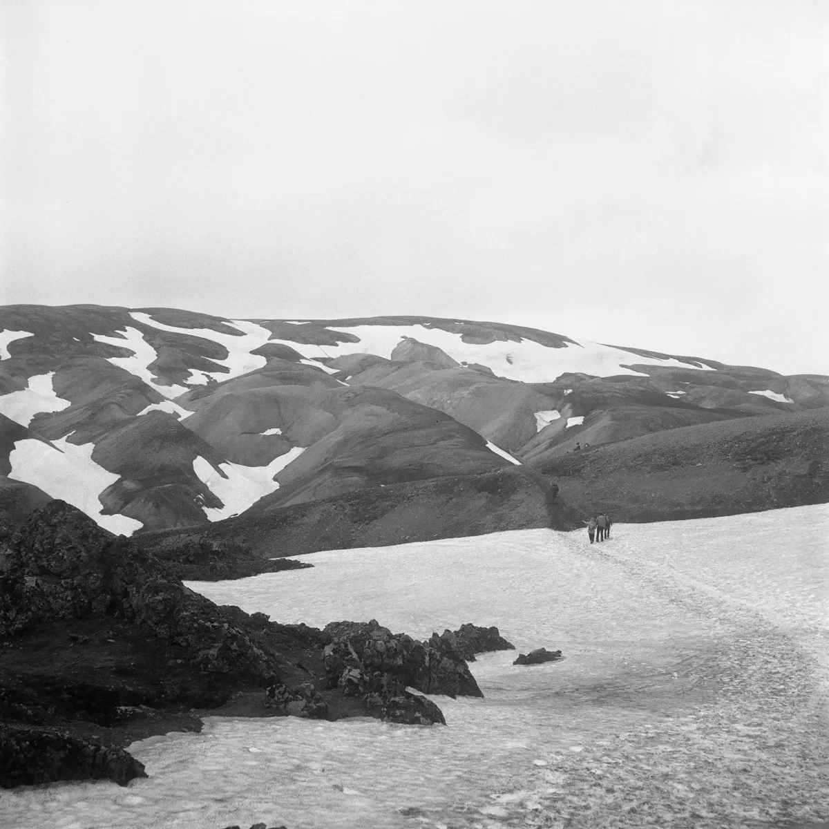 People hiking with mountains in background